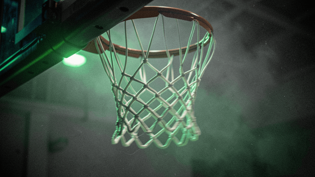 Basketball net and rim rendered with shallow depth and strong arena contrast